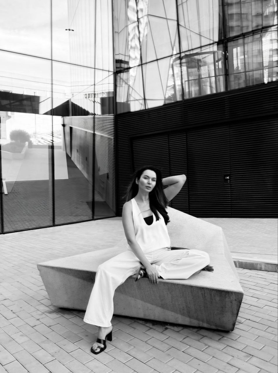 Yulia Nekhai sitting on a concrete bench in front of a glass building
